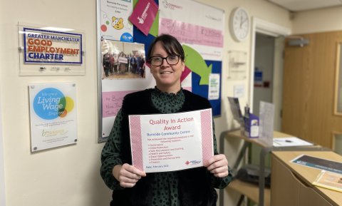 Trisha holding the Quality in Action certificate