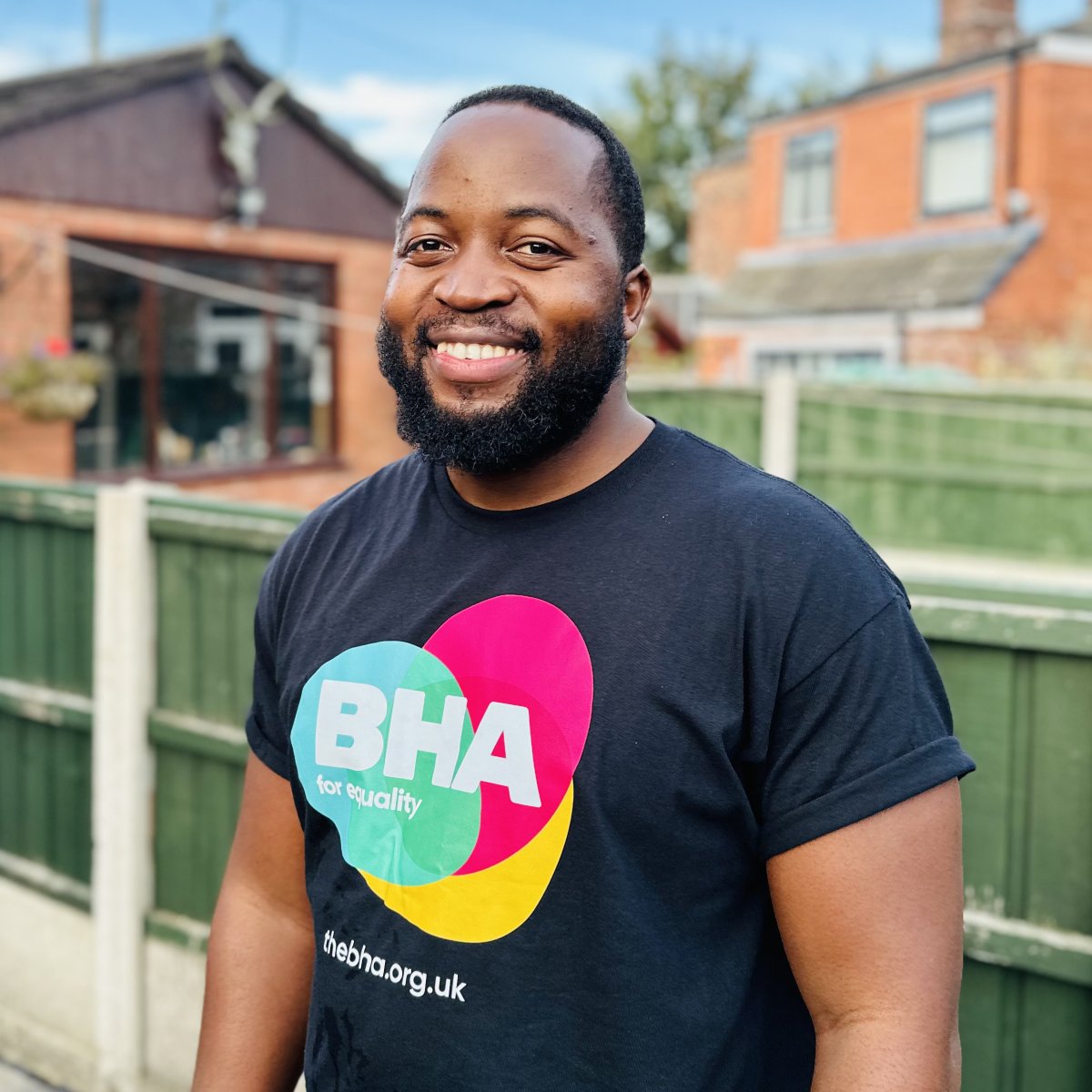 man with beard smiling in black tshirt with bright logo