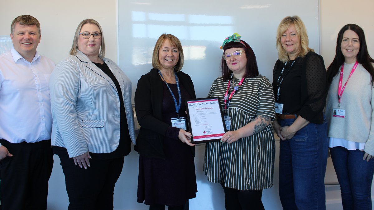 Rochdale Training receiving Quality in Action Award group smiling with certificate
