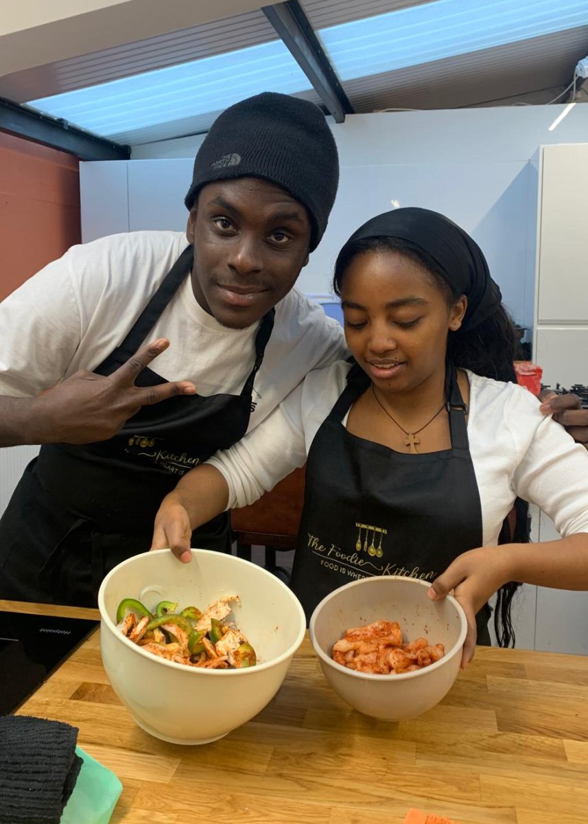 Young man and woman showing two bowls of food they are cooking