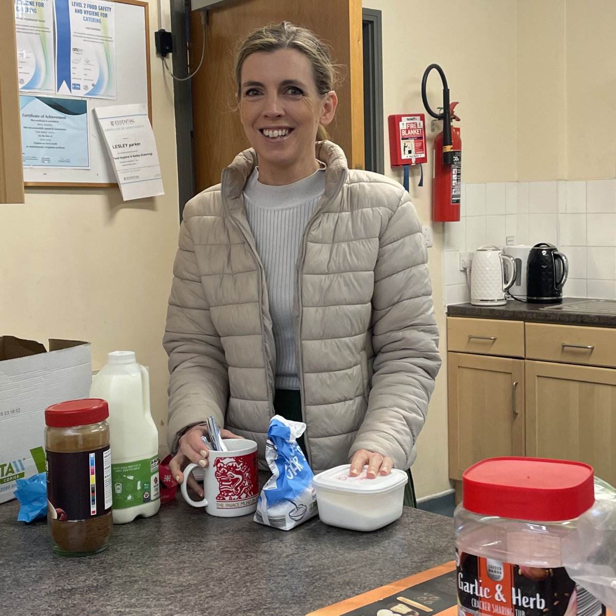 Lucy Clarke smiling at camera in kitchen while volunteering