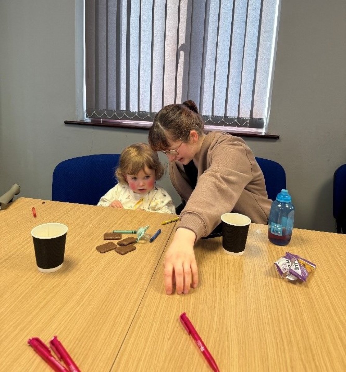 woman playing with child at a table 