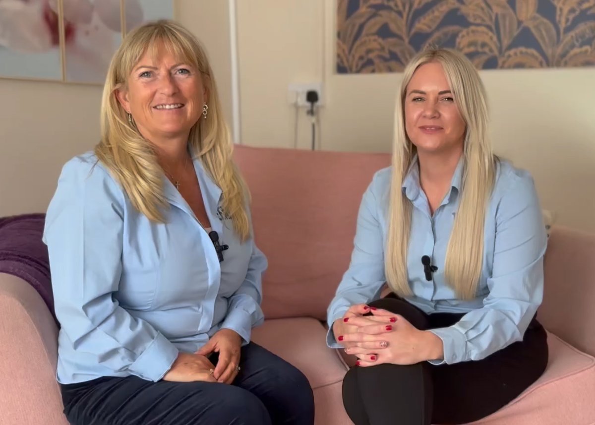 Two women sat on pink sofa smiling at camera (Melanie and Linze from Teen Lives Matter)