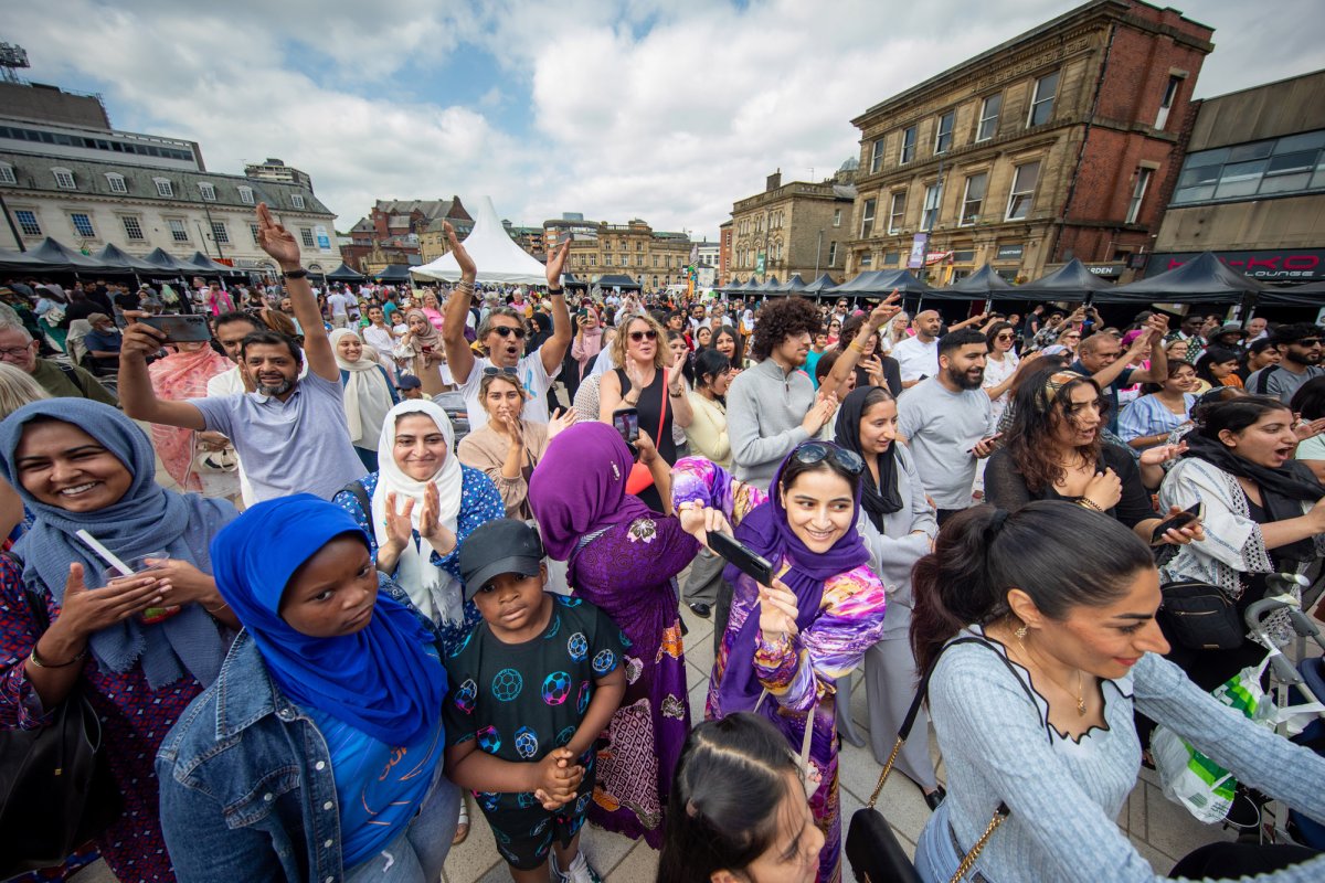Community crowd of people in colourful costumes enjoying street celebrations