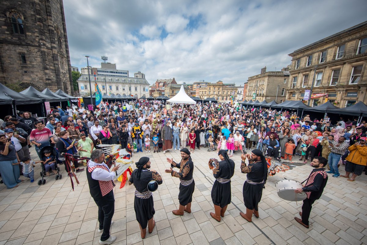Cultural band of street musician performers in front of large community crowd