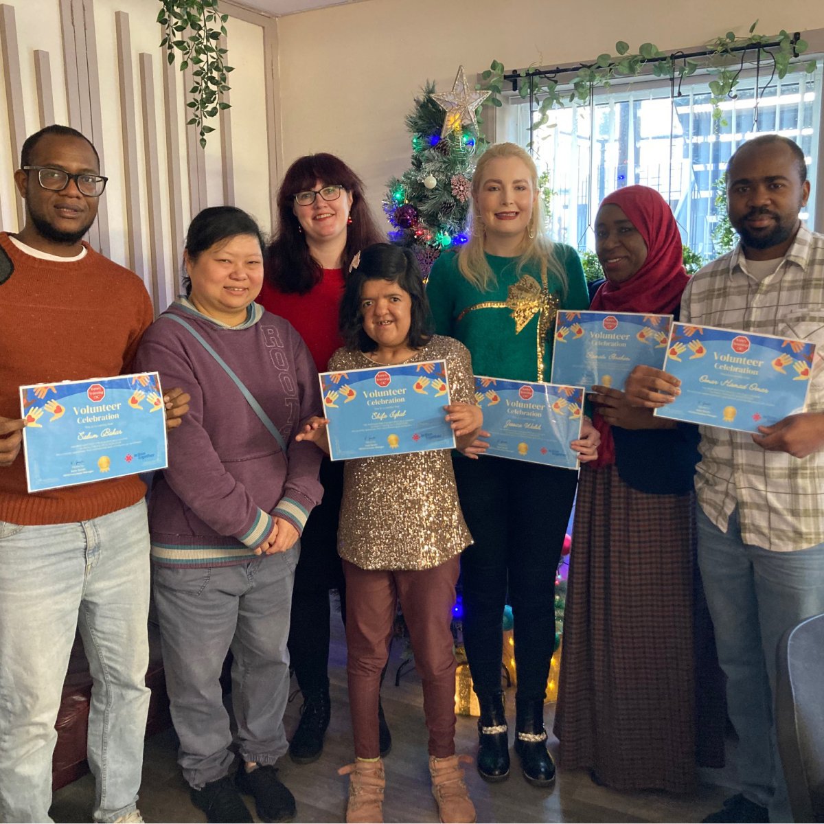 Group of volunteers from Kate's Training CIC smiling holding recognition certificates