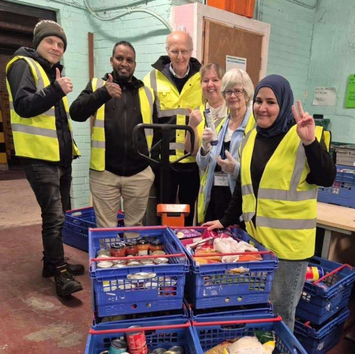 Photo of volunteers from Rochdale Foodbank with thumbs up surrounding crates of donated food, September 2026