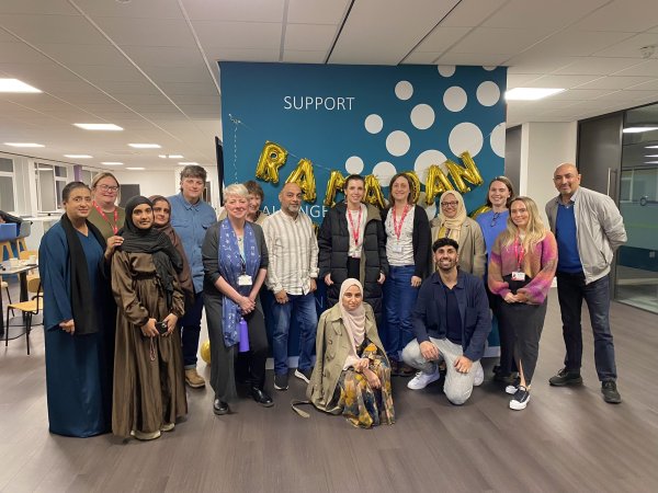 Group of people stood in front of blue wall