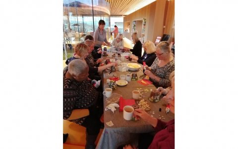 Group of ladies sat round a table doing arts and crafts